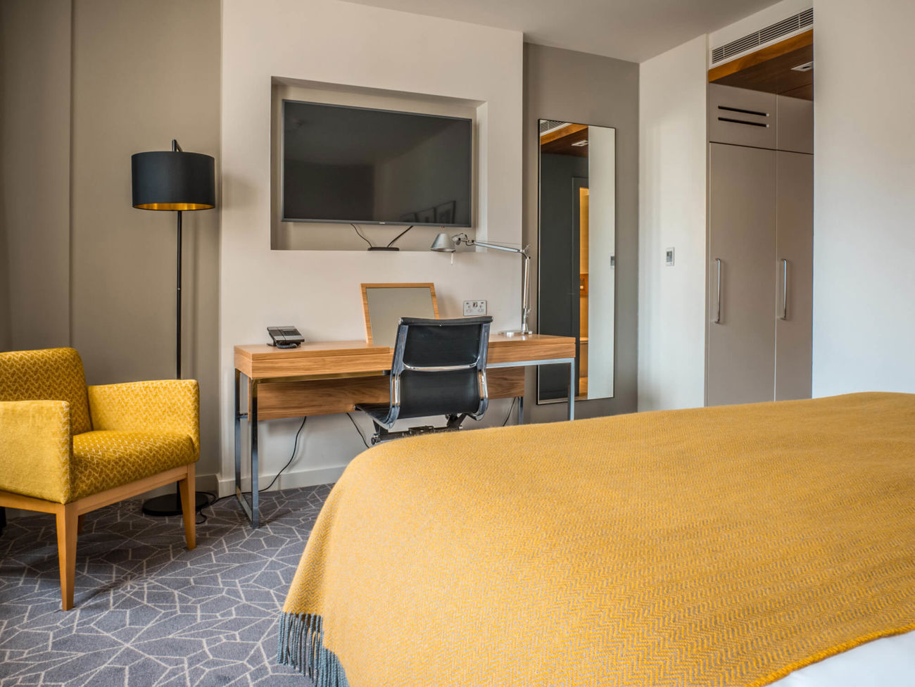 City Room work space area with chair, desk and widescreen TV at Apex Waterloo Place Hotel