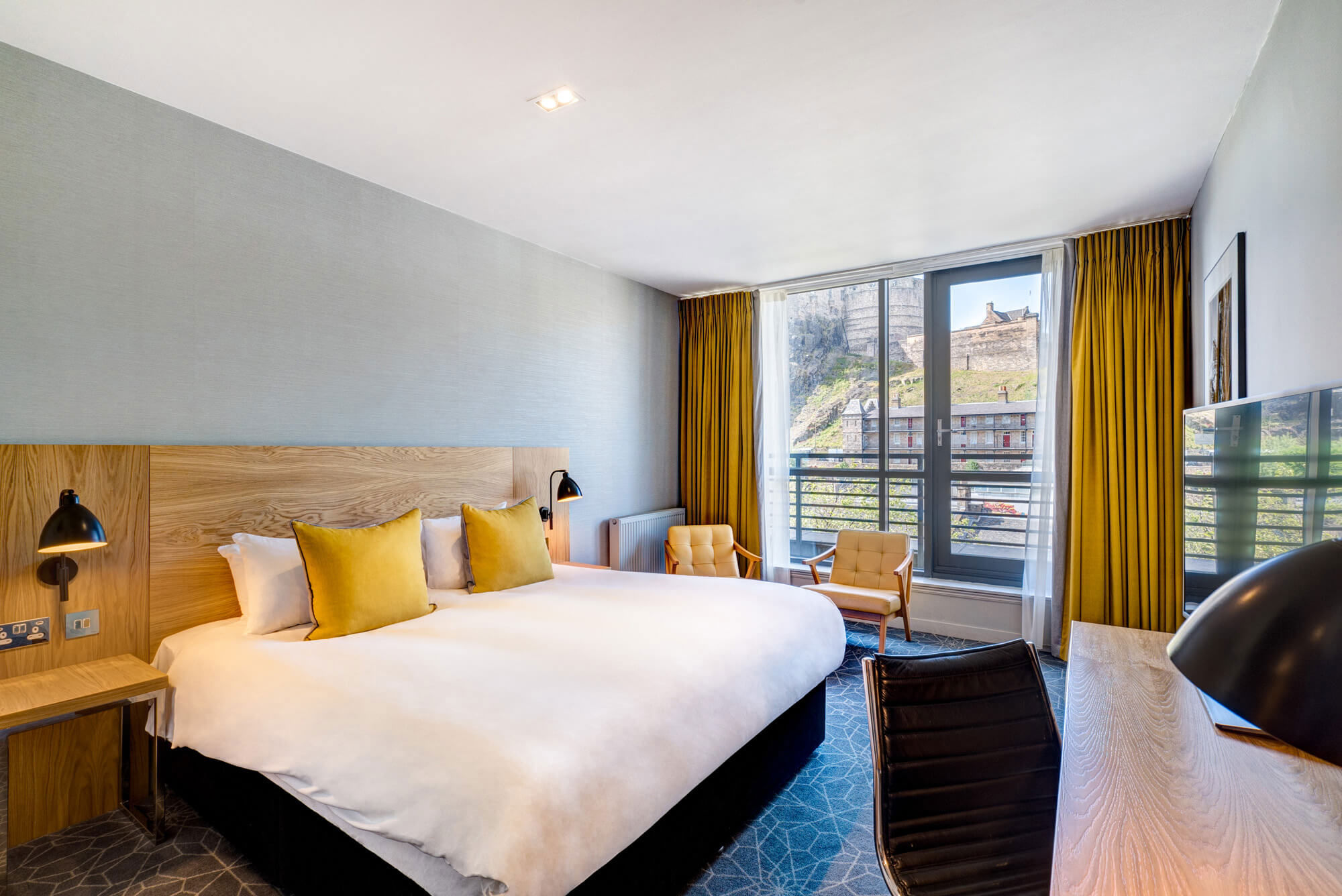Double Deluxe Bedroom with balcony view overlooking Edinburgh Castle at Apex Grassmarket Hotel