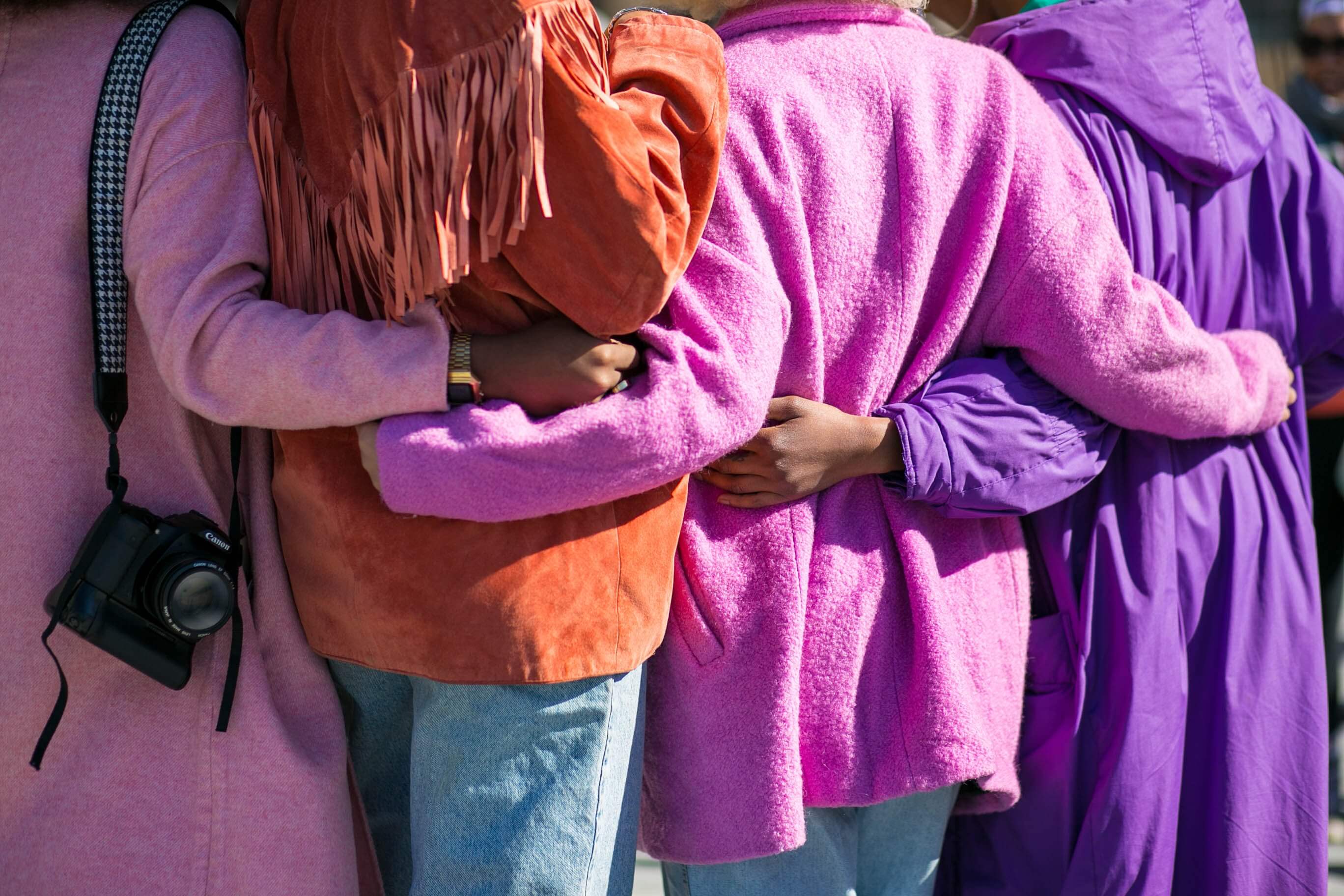 women with arms wrapped around each other